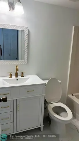 a bathroom with a toilet a sink and mirror