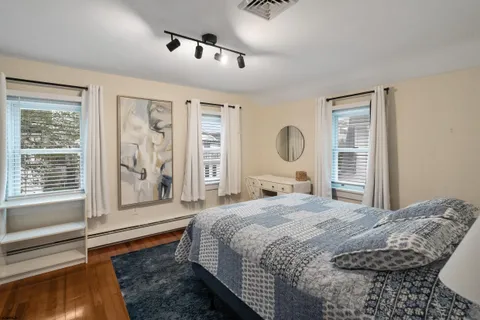 a bedroom with a bed and a large mirror next to a window