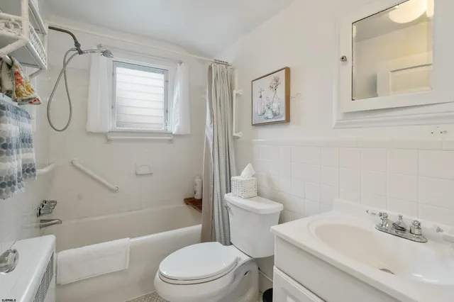 a bathroom with a toilet sink vanity tub and shower