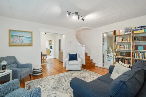 a living room with furniture and a wooden floor