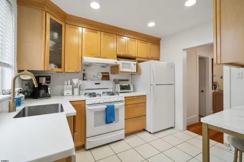 a kitchen with a refrigerator a stove top oven a sink and cabinets