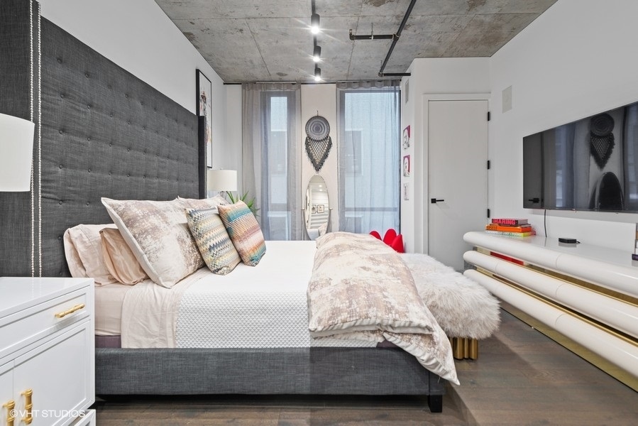 111 South Peoria Street, Unit 506 Chicago, IL 60607 - Photo 15 of 24 a bedroom with bed and a chandelier