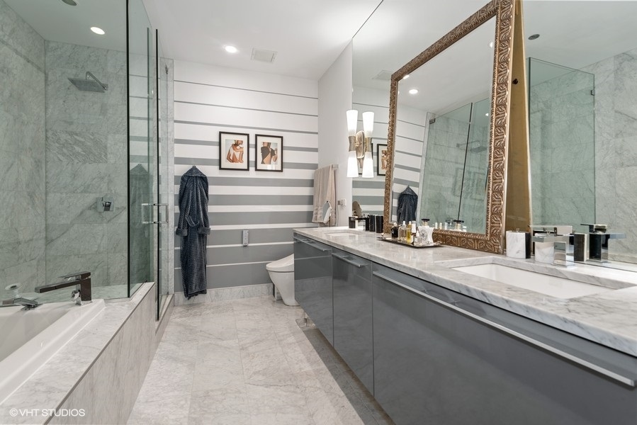 111 South Peoria Street, Unit 506 Chicago, IL 60607 - Photo 16 of 24 a bathroom with a double vanity sink a mirror and a bathtub