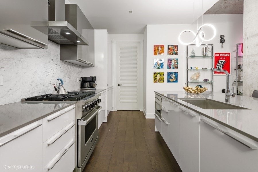 111 South Peoria Street, Unit 506 Chicago, IL 60607 - Photo 8 of 24 a kitchen with stainless steel appliances granite countertop a sink and cabinets