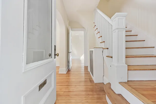a view of a hallway with white walls and wooden floor