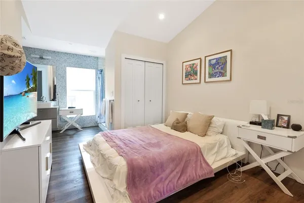 a bedroom with a bed and wooden floor