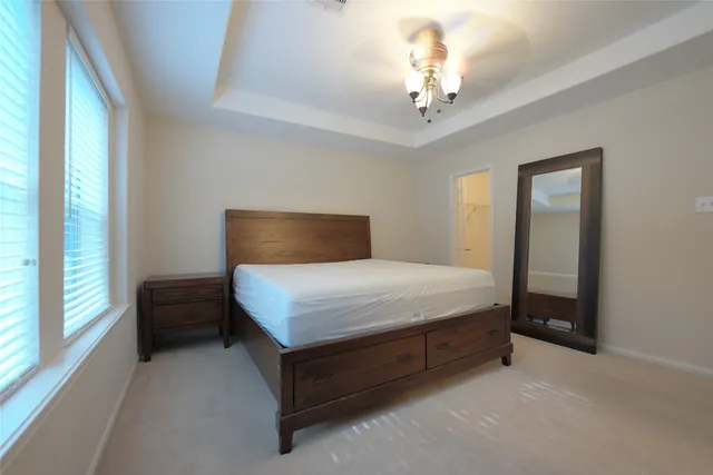 a bedroom with a bed and a chandelier