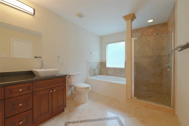 a bathroom with a granite countertop sink a toilet and bathtub