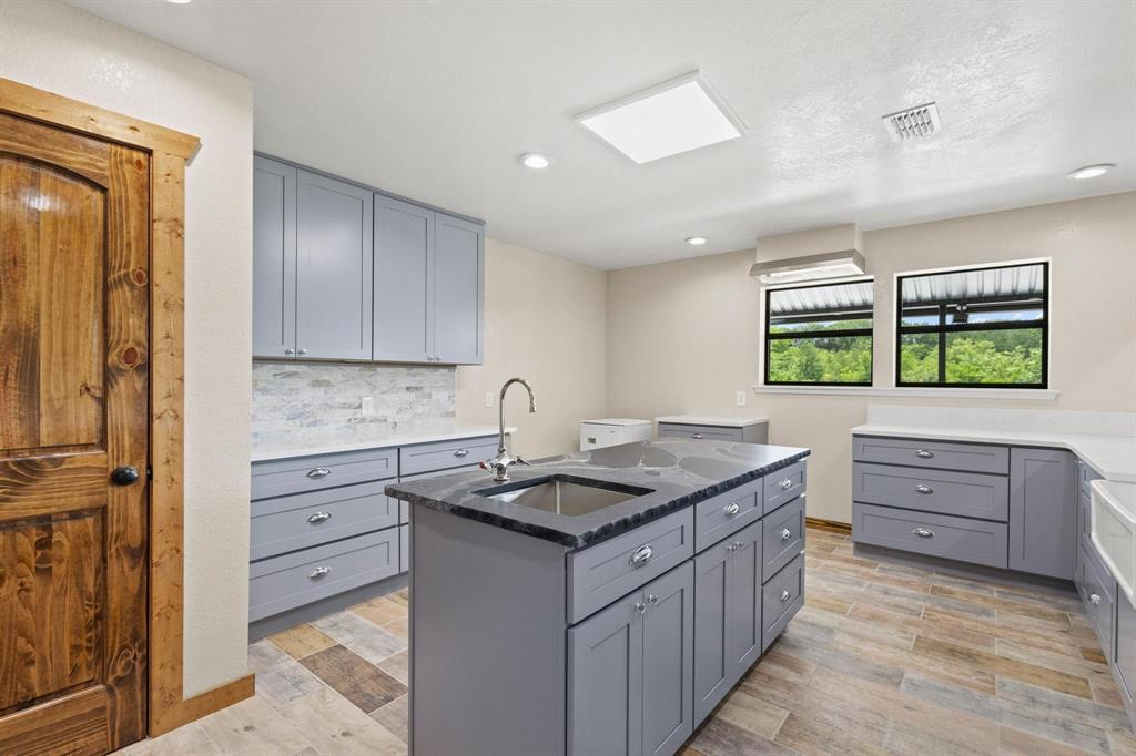 516 County Road Honey Grove, TX 75446 - Photo 11 of 27 a kitchen with kitchen island stainless steel appliances a stove and a sink