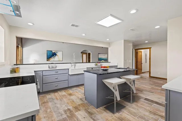 a kitchen with stainless steel appliances kitchen island granite countertop a sink and cabinets