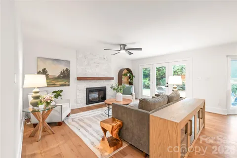 a living room with furniture a fireplace and a floor to ceiling window