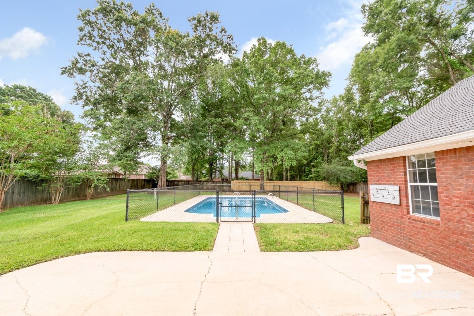 10691 Hunters Ridge Drive Mobile, AL 36695 - Photo 28 of 37 Expansive backyard featuring a fenced swimming pool, concrete patio, and a perimeter wood fence