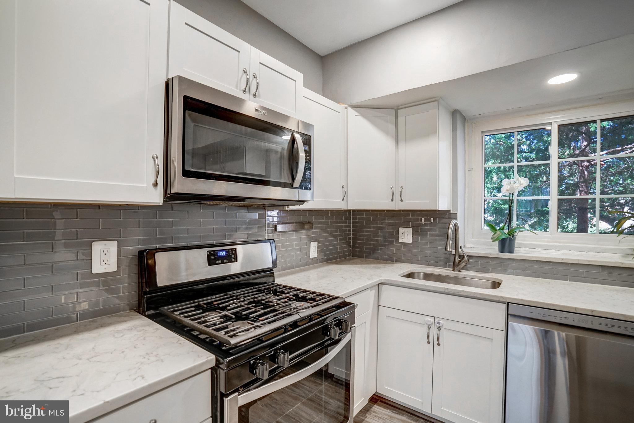 3239 Gunston Road Alexandria, VA 22302 - Photo 11 of 58 a kitchen with stainless steel appliances white cabinets granite counter tops and a window