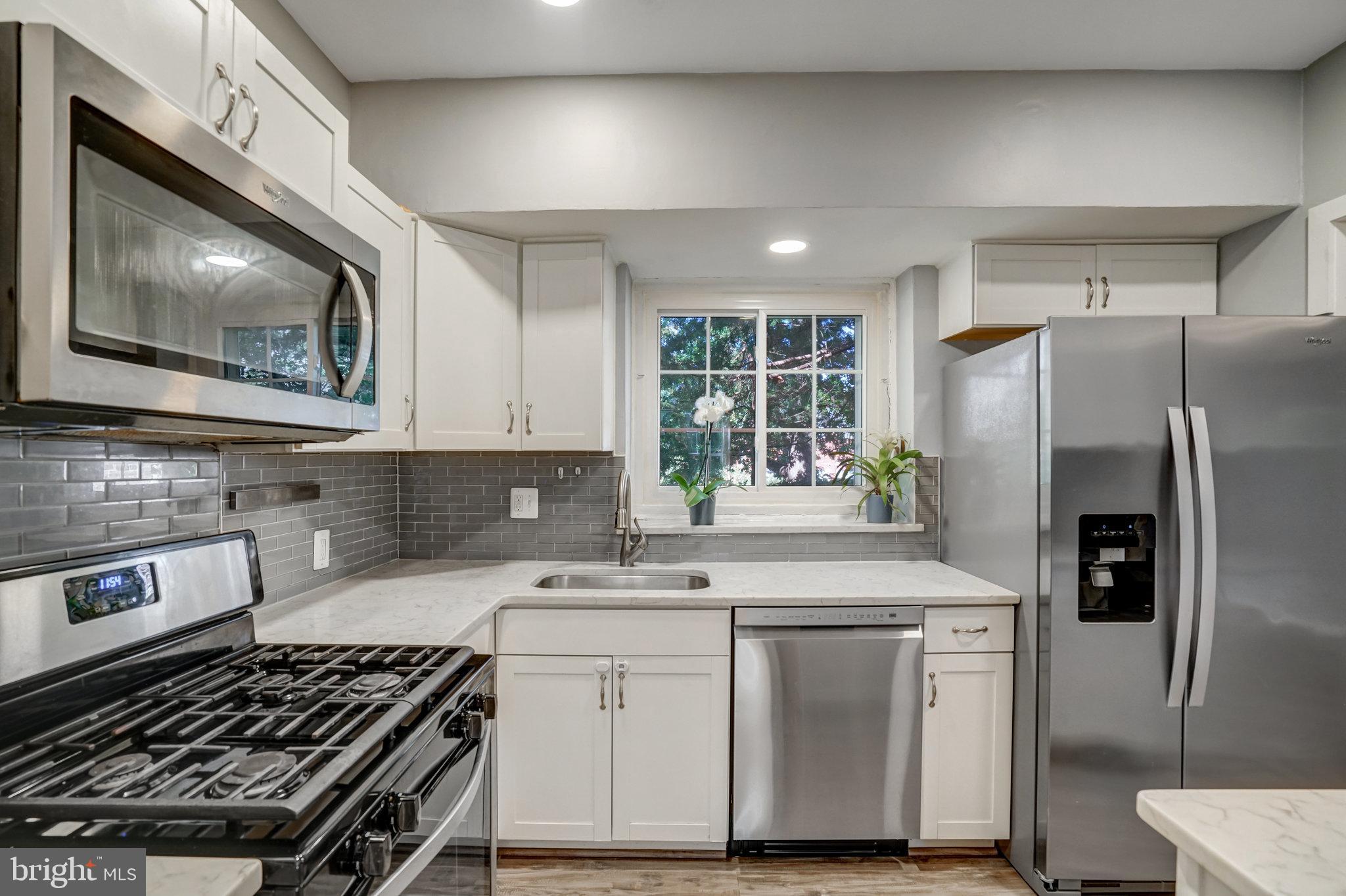 3239 Gunston Road Alexandria, VA 22302 - Photo 10 of 58 a kitchen with white cabinets stainless steel appliances and sink