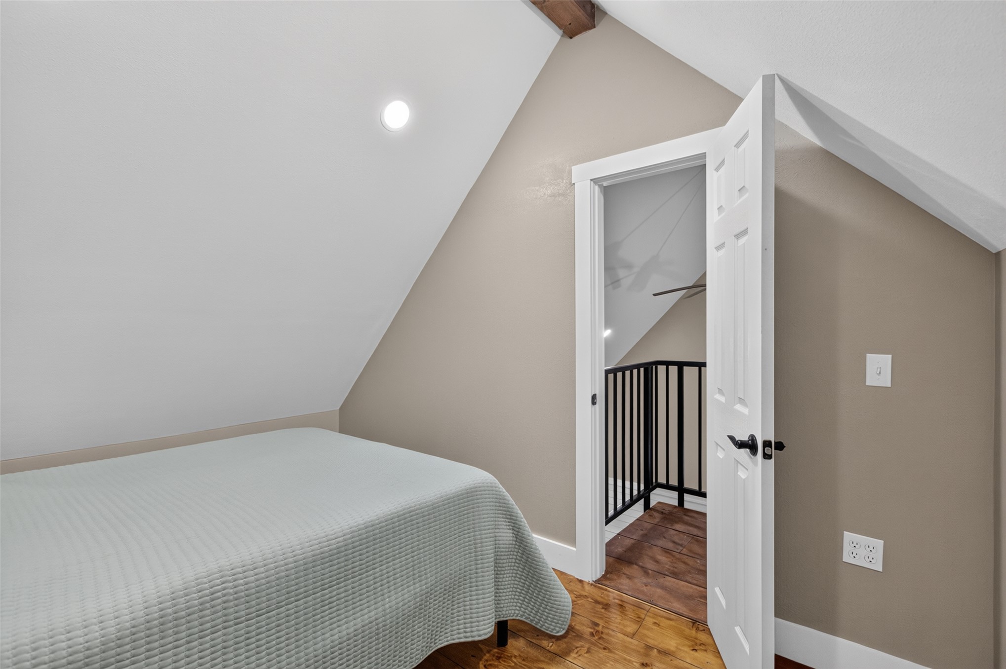 13063 East 403 Road Spavinaw, OK 74366 - Photo 14 of 25 Vaulted ceiling with recessed lighting, exposed ceiling beam, wood-finish flooring, white panel door with black hardware, and black metal railing