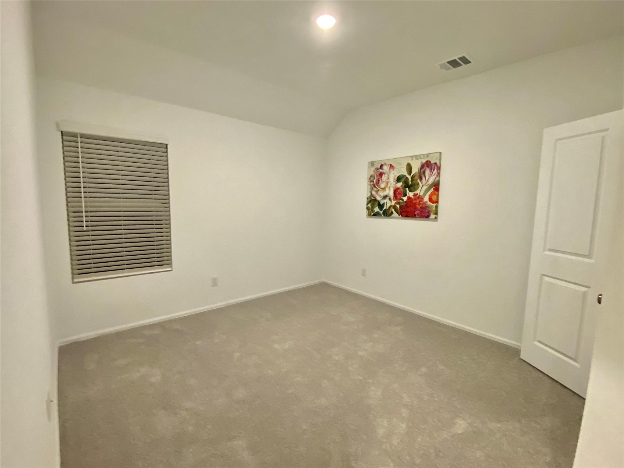 3724 Moss Hl Road Rosenberg, TX 77469 - Photo 23 of 29 This is a simple, well-lit room with neutral carpeting and white walls. It features a window with blinds, a decorative floral painting, and a door, making it versatile for various uses.