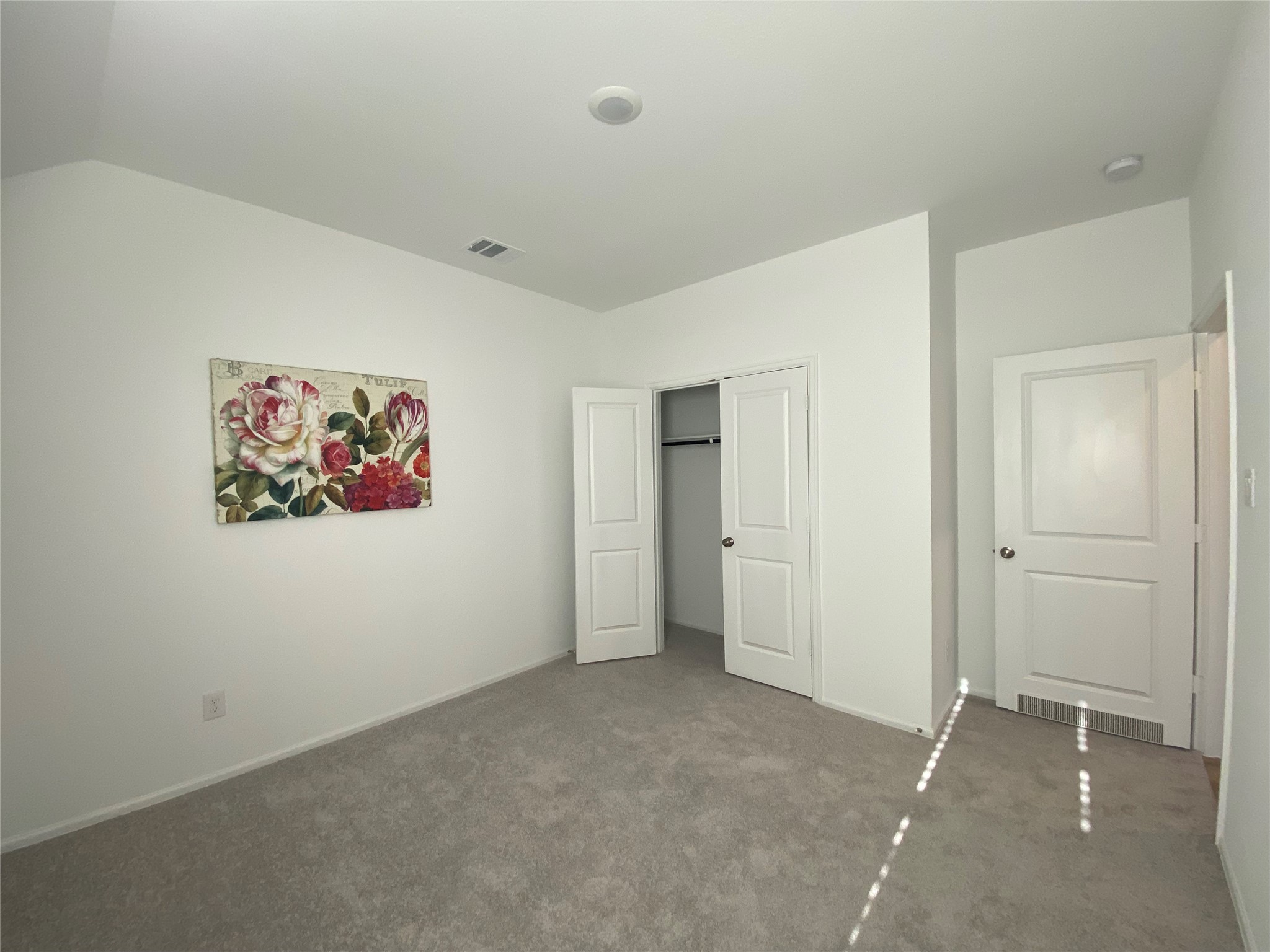 3724 Moss Hl Road Rosenberg, TX 77469 - Photo 24 of 29 This room features neutral carpeting and walls with a floral painting adding a touch of color. It includes a closet with double doors and is well-lit by natural light.