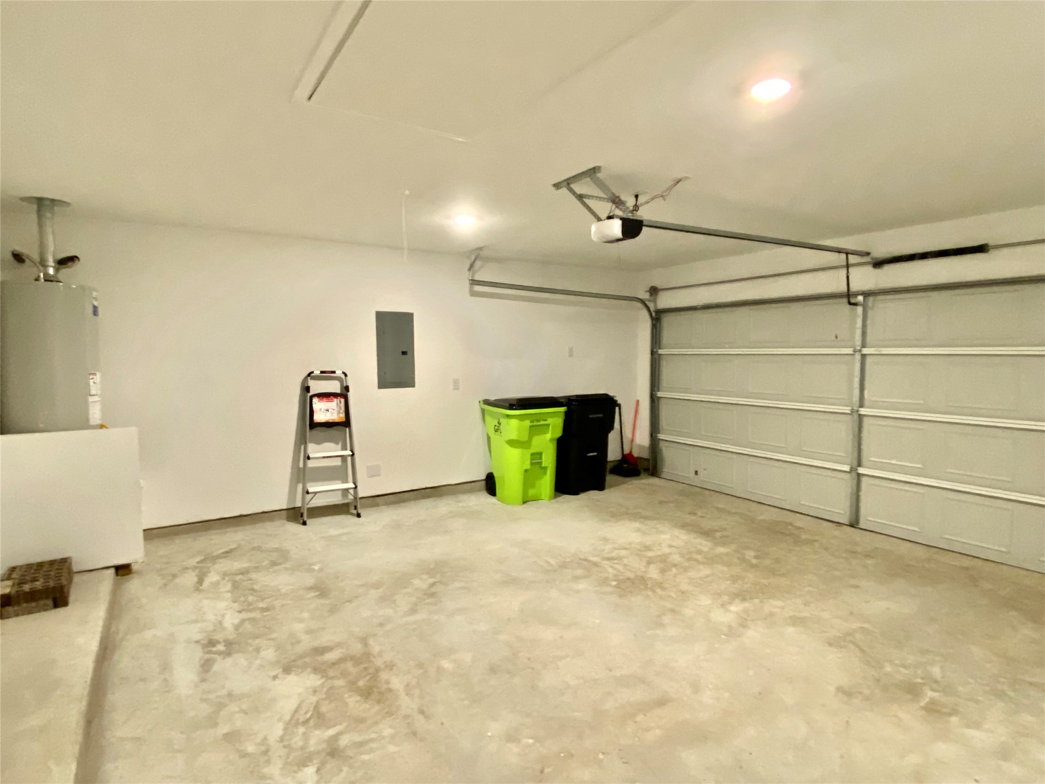 3724 Moss Hl Road Rosenberg, TX 77469 - Photo 26 of 29 This is a spacious two-car garage with a concrete floor, equipped with a water heater and overhead lighting. It has a garage door opener and basic utilities, making it ideal for storage or parking.