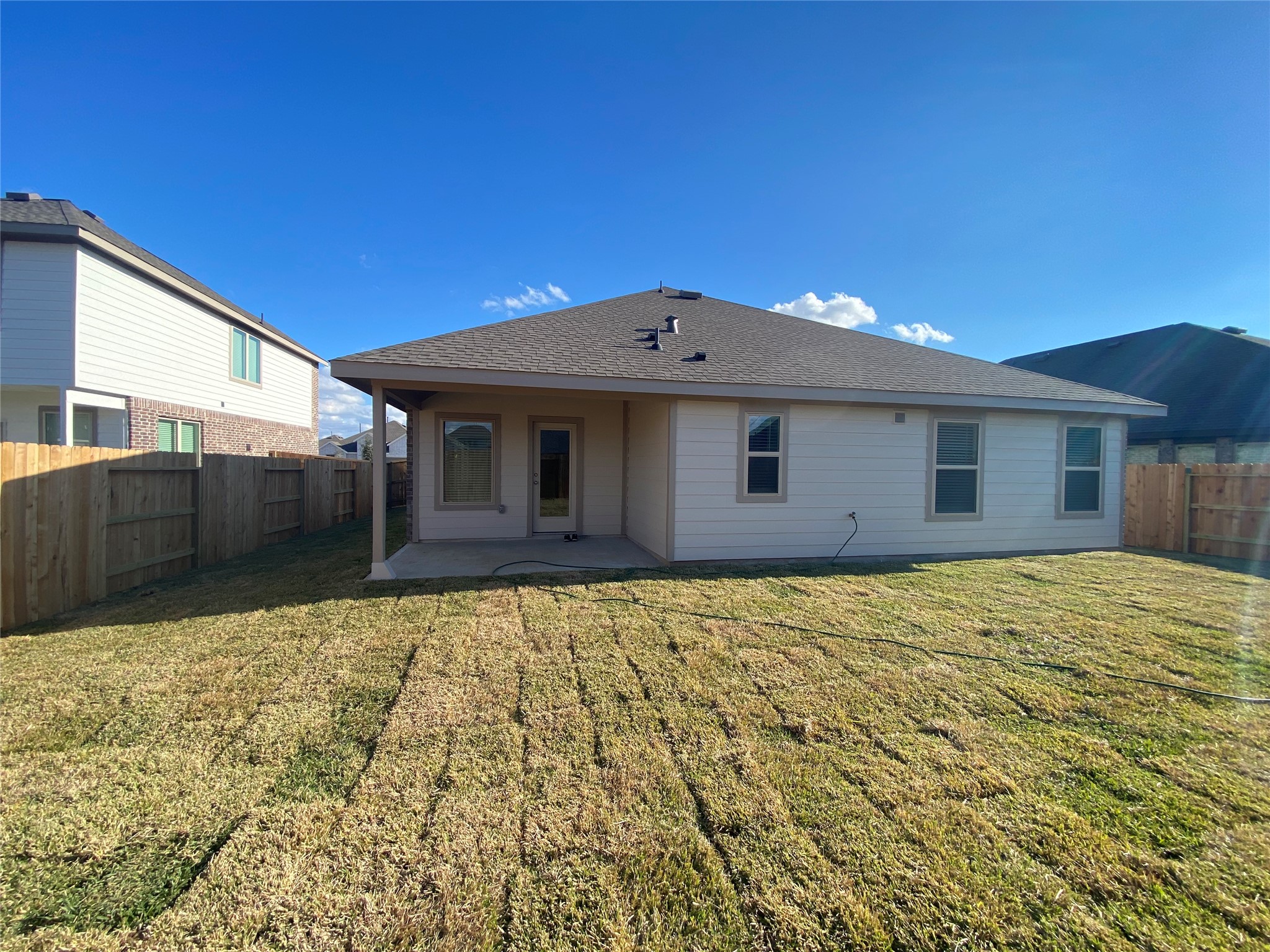 3724 Moss Hl Road Rosenberg, TX 77469 - Photo 28 of 29 This photo shows the backyard of a single-story home with a covered patio and a neatly maintained lawn. The yard is fenced, providing privacy and a secure space for outdoor activities.