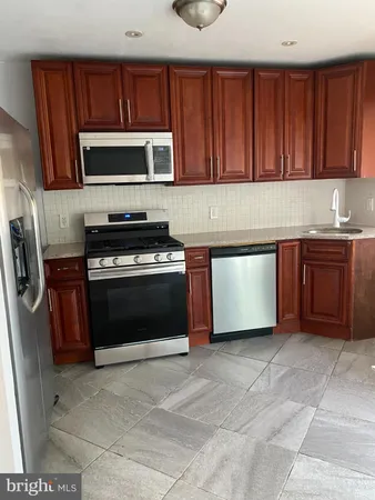 a kitchen with stainless steel appliances granite countertop a stove a microwave and a sink