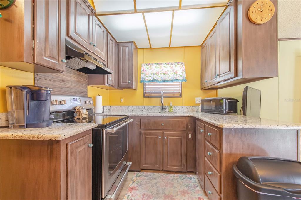 475 Pine Loop Frostproof, FL 33843 - Photo 9 of 40 a kitchen with stainless steel appliances granite countertop a sink a stove and a microwave