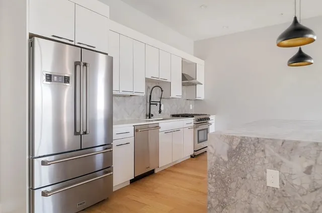a kitchen with stainless steel appliances a refrigerator sink and stove