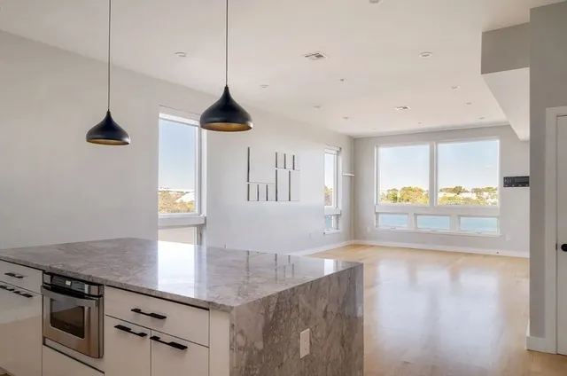 a kitchen with stainless steel appliances granite countertop a sink a stove and a wooden floors