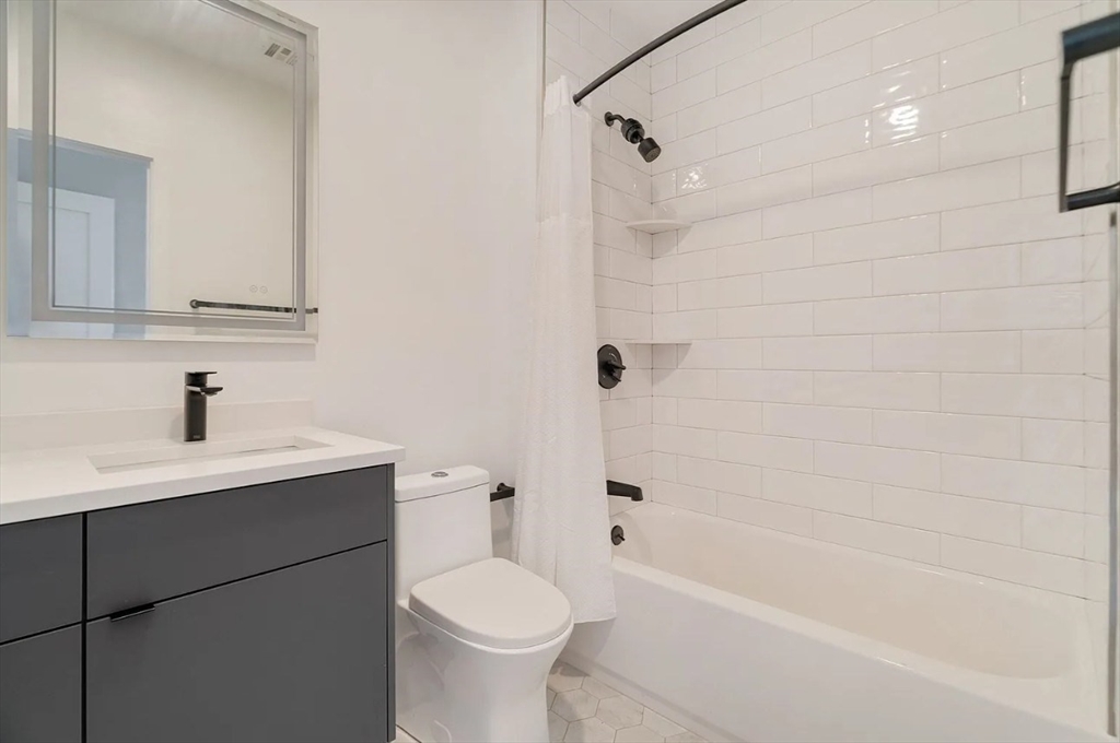 243 Condor Street, Unit 4 Boston, MA 02128 - Photo 8 of 13 a bathroom with a sink a toilet and shower