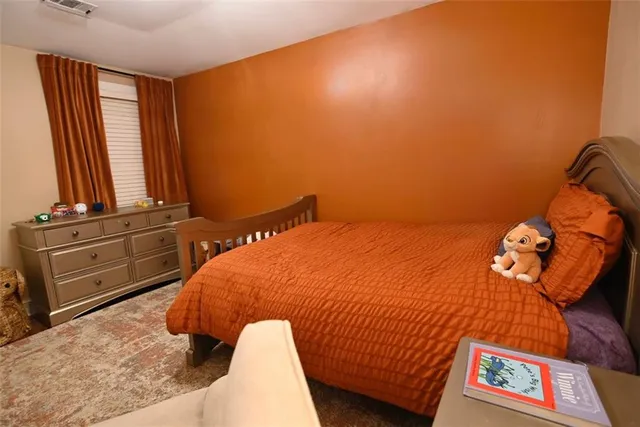 a bed sitting in a bedroom next to a window with dresser