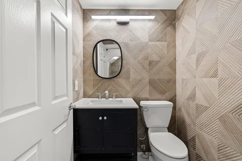 a bathroom with a toilet sink and mirror