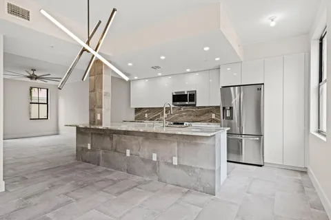 a kitchen with stainless steel appliances granite countertop a refrigerator a stove and a sink