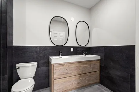 a bathroom with a toilet sink and mirror