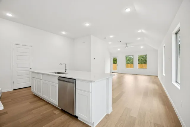 a view of a kitchen with kitchen island a sink wooden floor and a refrigerator