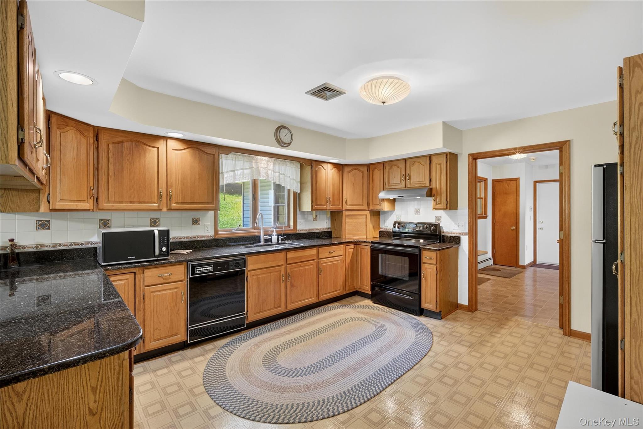 561 Toleman Road Rock Tavern, NY 12575 - Photo 12 of 31 a kitchen with stainless steel appliances granite countertop a stove a sink dishwasher a refrigerator and white cabinets with wooden floor