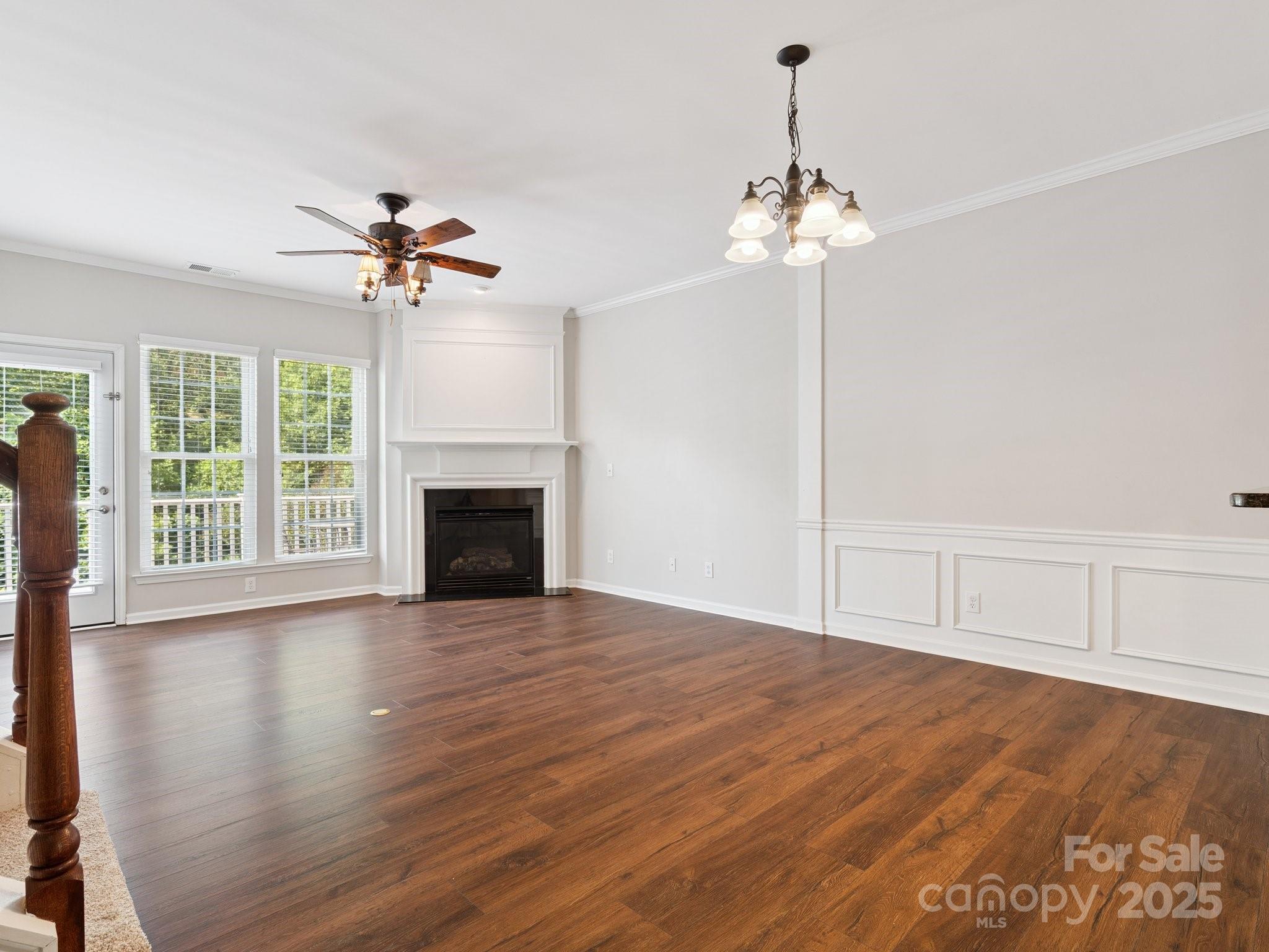 570 6th Baxter Crossing Fort Mill, SC 29708 - Photo 13 of 37 a view of an empty room with a chandelier fan and wooden floor