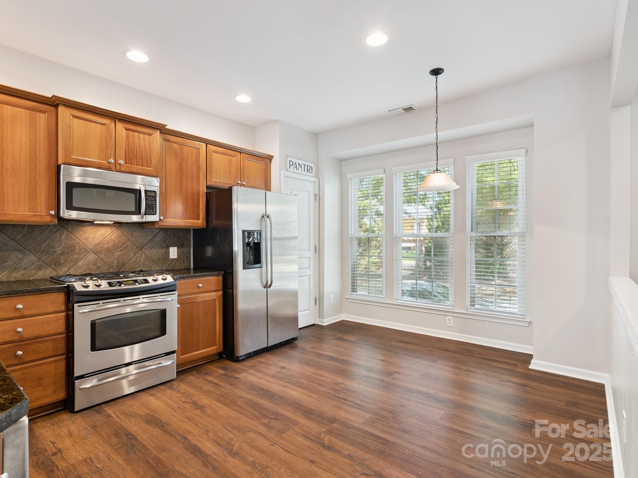 570 6th Baxter Crossing Fort Mill, SC 29708 - Photo 9 of 37 a kitchen with stainless steel appliances granite countertop a refrigerator a stove top oven a sink and a wooden floors