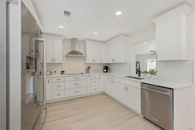 a large kitchen with stainless steel appliances kitchen island granite countertop a refrigerator and a sink