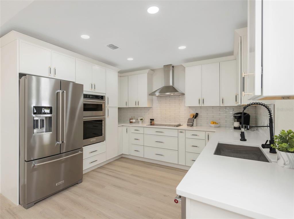 11419 47th Avenue North St. Petersburg, FL 33708 - Photo 26 of 94 a kitchen with stainless steel appliances a refrigerator sink and cabinets