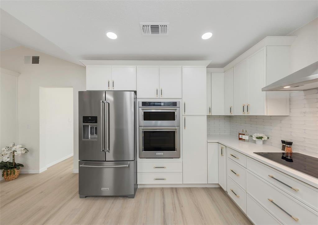 11419 47th Avenue North St. Petersburg, FL 33708 - Photo 28 of 94 a kitchen with stainless steel appliances a refrigerator stove and white cabinets