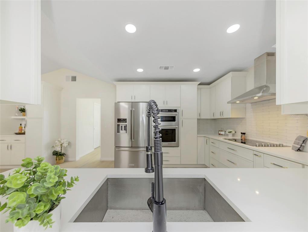 11419 47th Avenue North St. Petersburg, FL 33708 - Photo 44 of 94 a large kitchen with stainless steel appliances kitchen island granite countertop a refrigerator and a sink