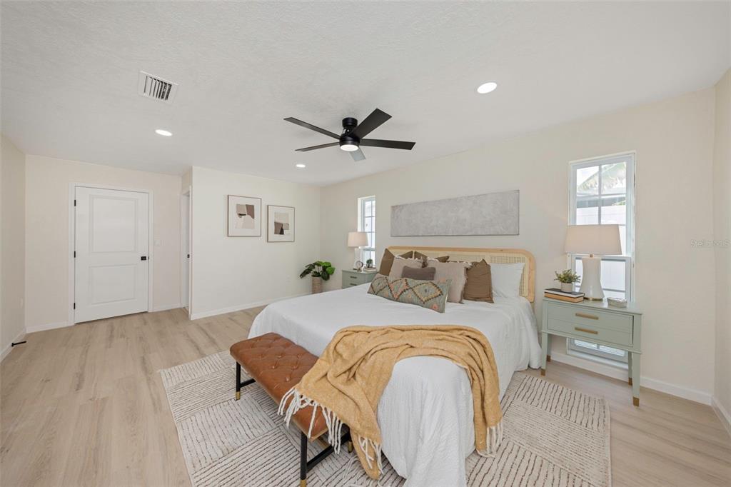 11419 47th Avenue North St. Petersburg, FL 33708 - Photo 54 of 94 a spacious bedroom with a bed and a ceiling fan