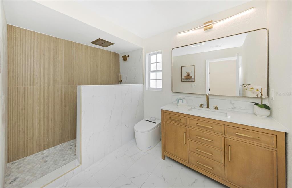 11419 47th Avenue North St. Petersburg, FL 33708 - Photo 60 of 94 a spacious bathroom with a double vanity sink a mirror and a toilet