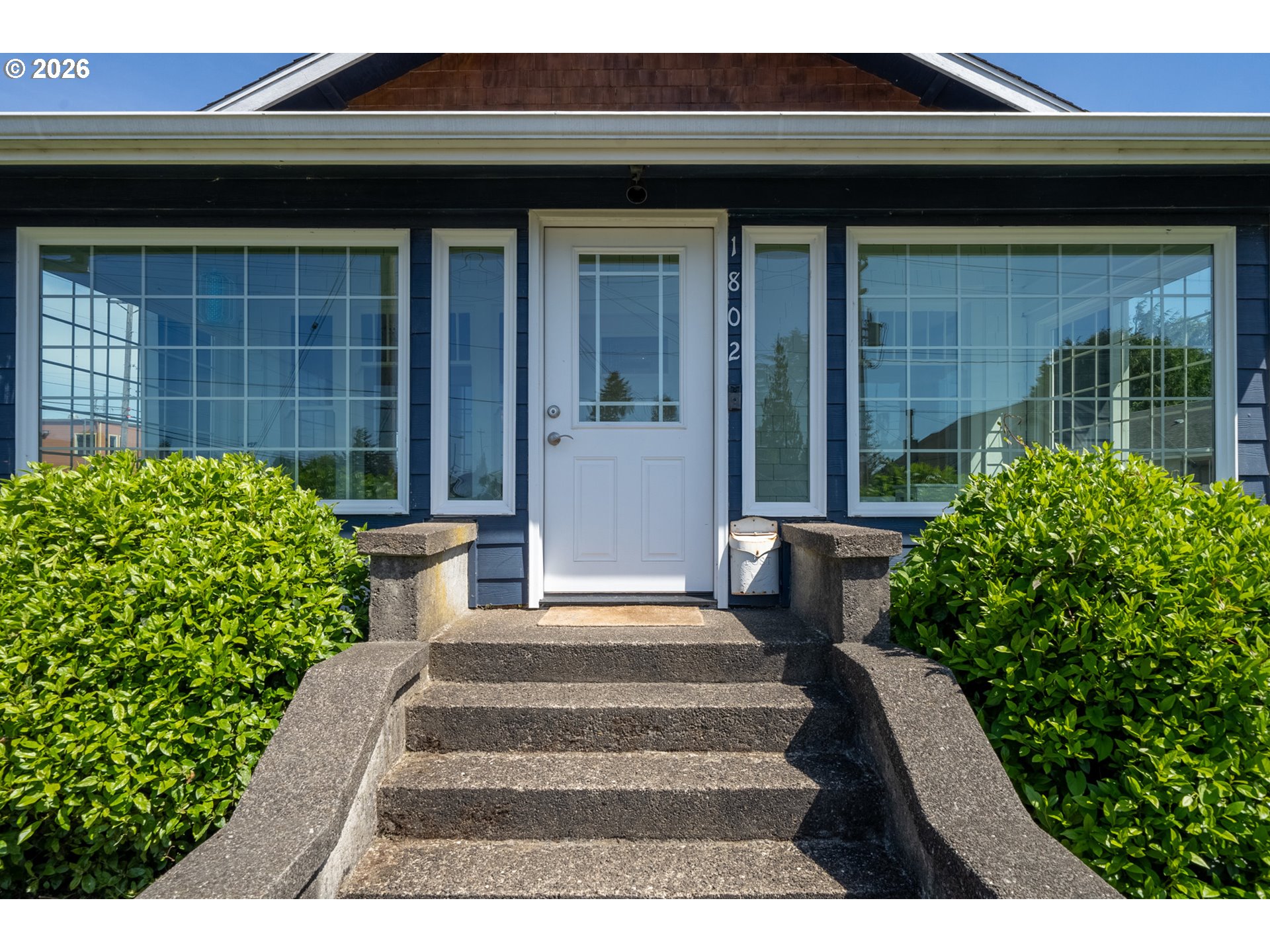 1802 8th Street Tillamook, OR 97141 - Photo 3 of 37 a front view of a house with a garden