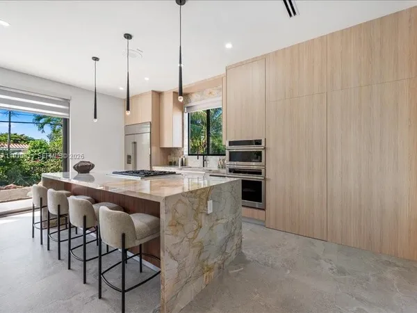 a open kitchen with stainless steel appliances granite countertop a sink a stove and a wooden floors