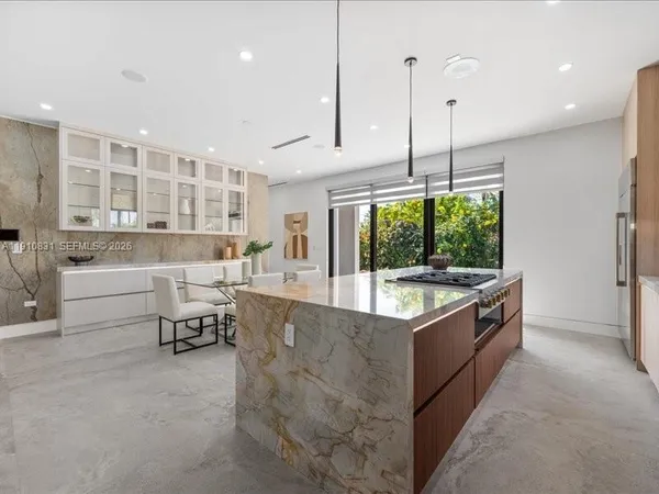 a large kitchen with stainless steel appliances granite countertop a stove and a wooden cabinets