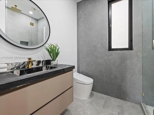 a bathroom with a toilet a sink and mirror