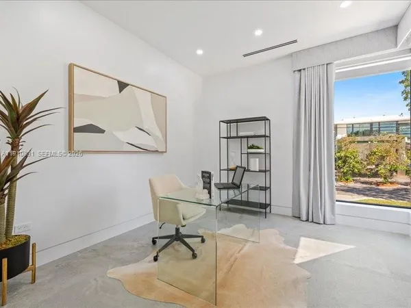a view of a workspace with furniture and a window