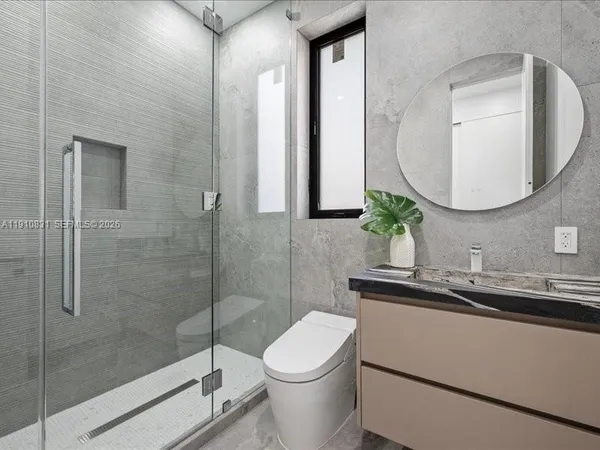 a bathroom with a toilet a sink and mirror