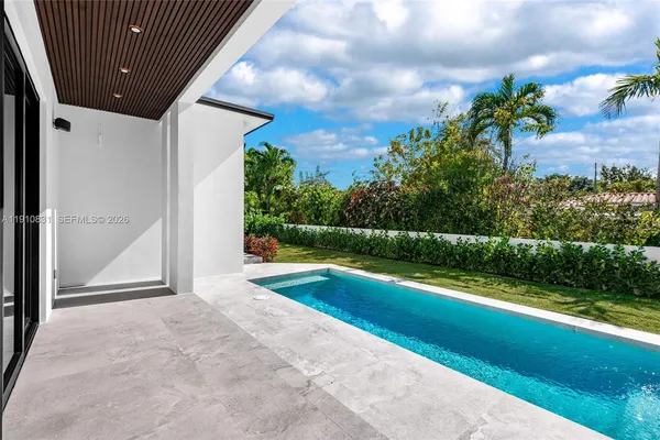 a view of swimming pool with yard in front of it