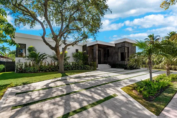 a view of a house with a yard and large tree